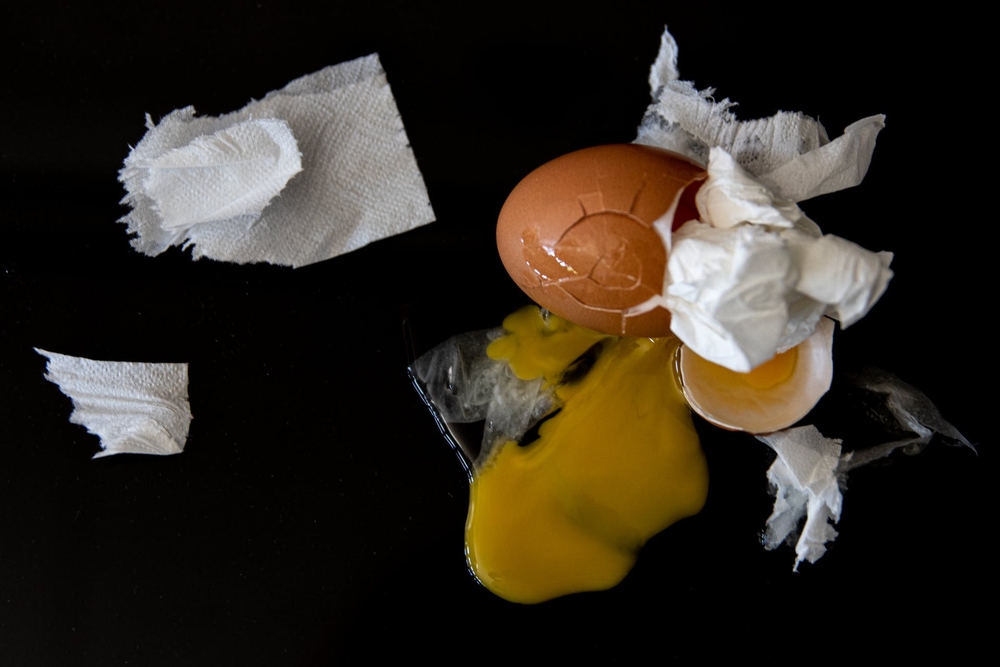 Cracked Egg and Tissue Paper on a Black Background